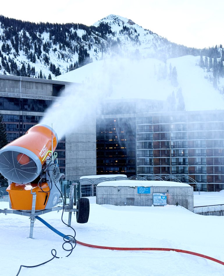 DEMACLENKO Ventus 4.0 BLIZZARD fan gun making snow beside a resort building